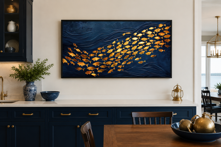 Framed nautical canvas art featuring a school of gold fish swimming in a deep navy blue ocean.