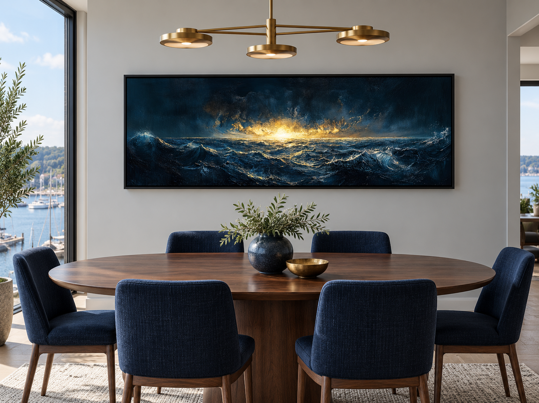 Navy gold ocean sunset canvas art in a modern dining room above a wooden table with blue chairs.