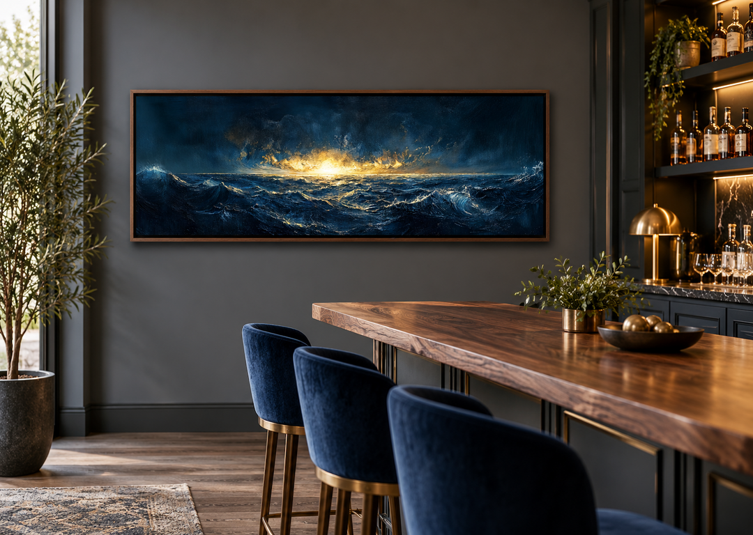 Navy and gold ocean sunset canvas art in a panoramic frame above a modern home bar.