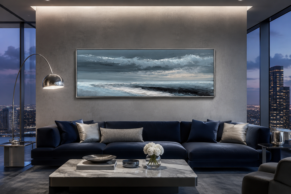 Navy blue and grey abstract ocean long horizontal wall art hanging above a dark blue sofa.