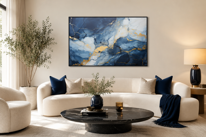 Navy blue, grey, and gold abstract marble canvas wall art framed above a white sofa.
