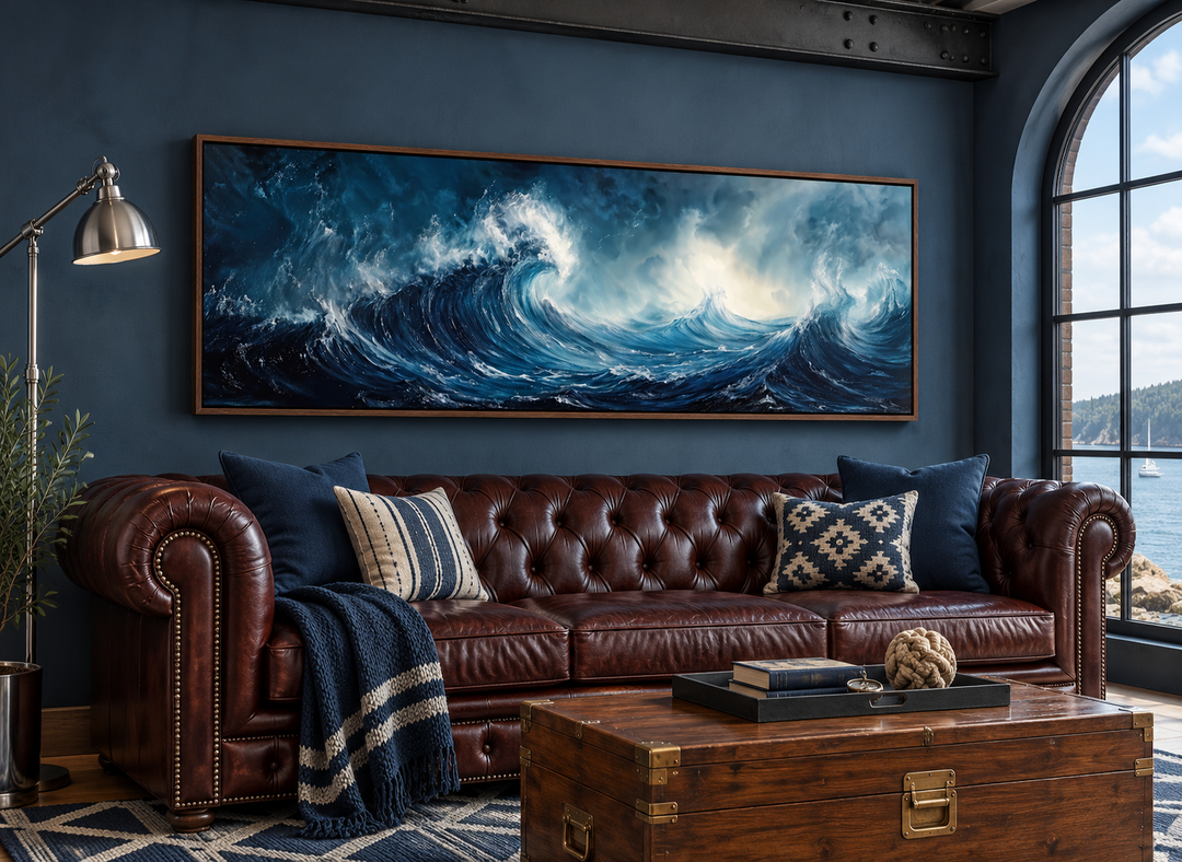 Long horizontal framed canvas wall art featuring abstract navy and blue ocean waves above a sofa.