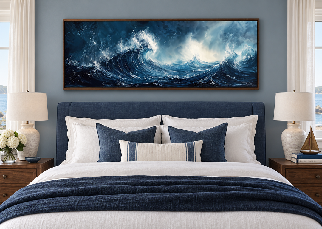 Long horizontal navy and blue abstract ocean wave framed canvas wall art above a bed.
