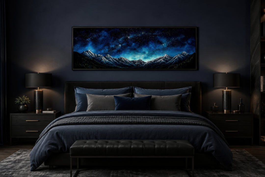 Navy blue starry night sky over mountains horizontal framed canvas wall art above a bed.