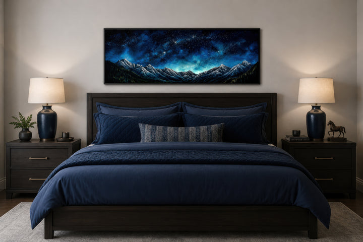 Navy blue starry night sky over mountains horizontal framed canvas wall art above a bed.