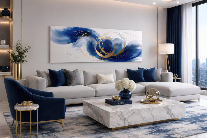 Blue, white, and gold minimalist abstract narrow horizontal wall art hanging above a sofa.