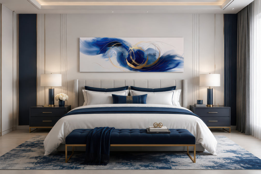Blue, white, and gold minimalist abstract horizontal canvas art hanging above a bed.