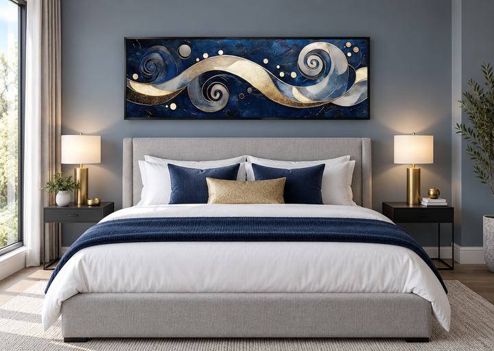 Navy and gold abstract swirl canvas art above a bed in a modern bedroom with blue and gold accents.