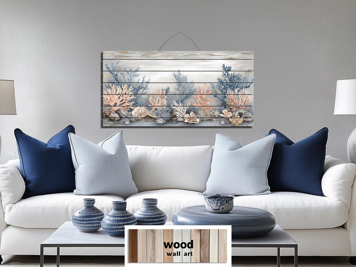Horizontal wood wall art featuring coral in beige, blue, and peach tones above a white sofa.