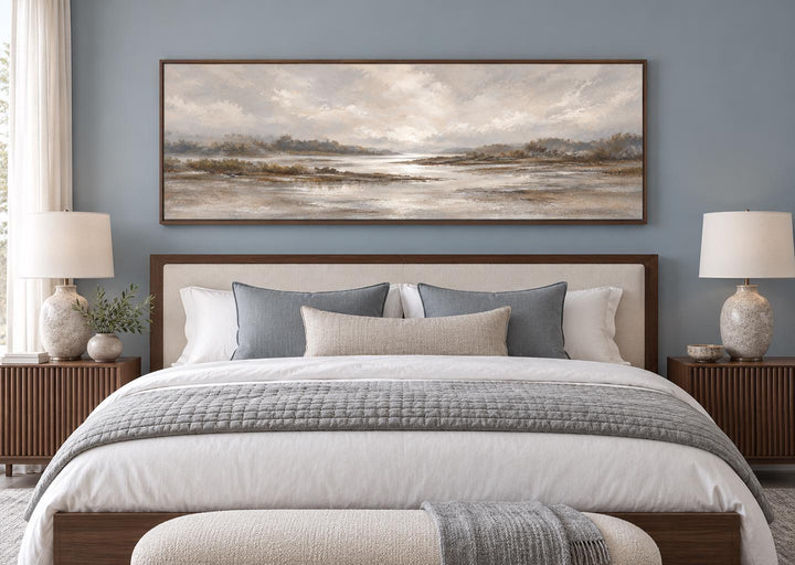Neutral earth tones river landscape long horizontal canvas wall art above a bed in a bedroom.