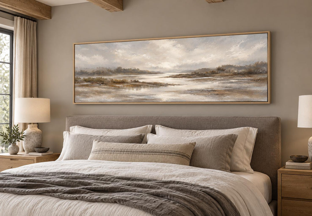 Neutral earth tones river landscape long horizontal canvas wall art above a bed in a bedroom.