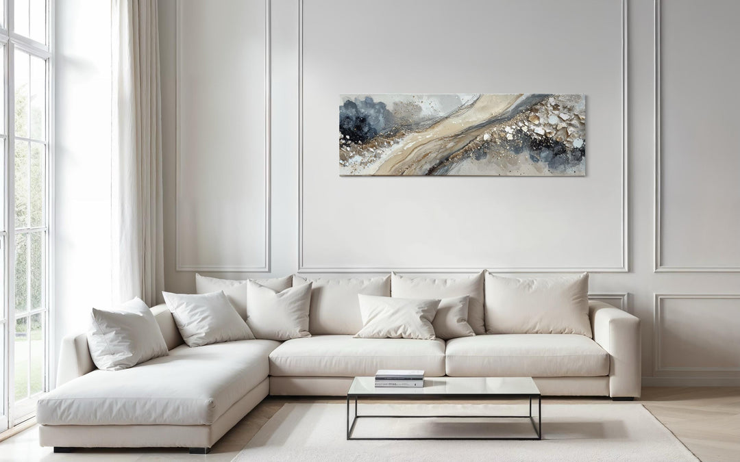 Neutral grey, beige, and gold horizontal abstract canvas art hanging above a modern white sofa.