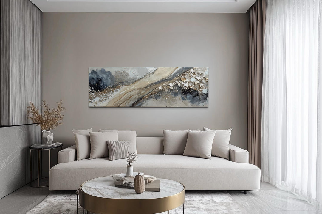 Neutral grey, beige, and gold long horizontal abstract canvas wall art hanging above a modern couch.
