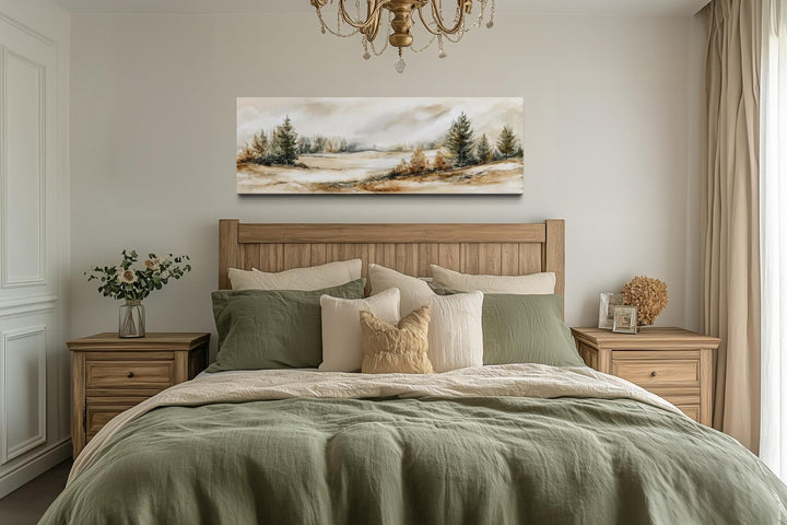 Panoramic neutral landscape canvas print in beige, brown, and green tones above a wooden bed.