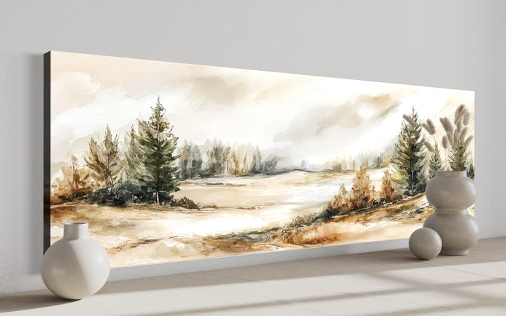 Panoramic canvas print of a neutral landscape in beige, brown, and green tones on a white wall.