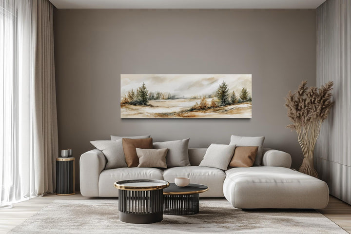 Panoramic canvas print of a neutral landscape with beige and green trees over a modern sofa.