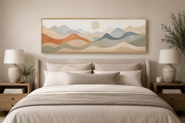 Neutral layered mountain landscape canvas art hanging above a bed in a minimalist bedroom.