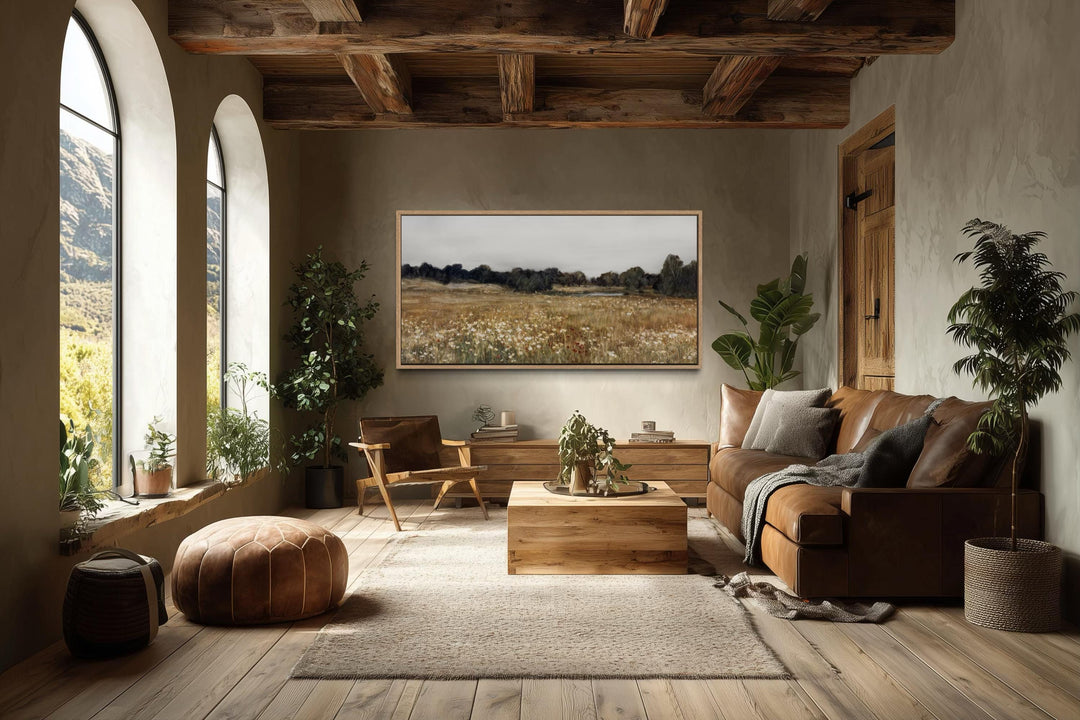 Neutral wildflower field landscape canvas wall art displayed in a rustic farmhouse living room.