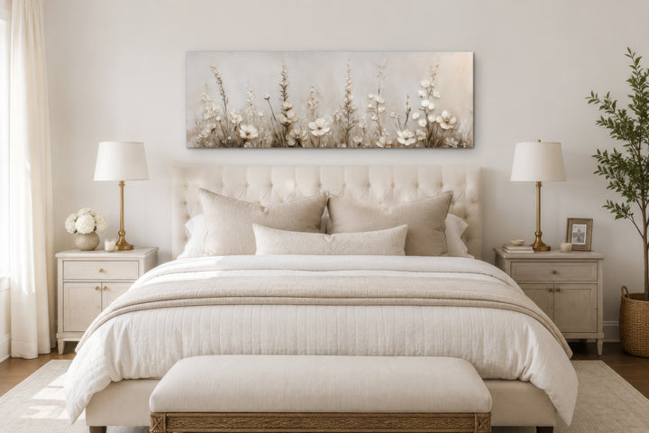 Neutral wildflower canvas print with beige floral details above a bed in a calm bedroom.
