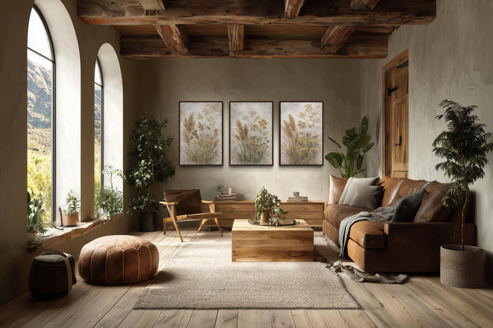Set of three neutral wildflower botanical canvas prints displayed in a rustic living room.