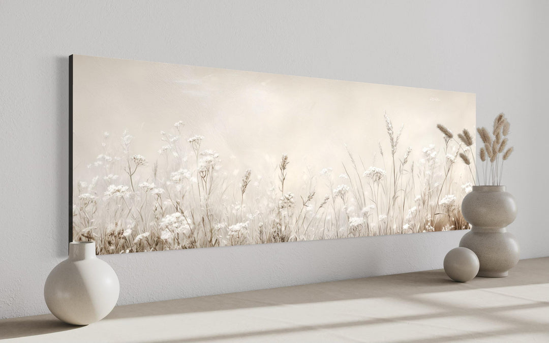 Horizontal canvas wall art of neutral wildflowers and meadow grasses in beige and off-white tones.