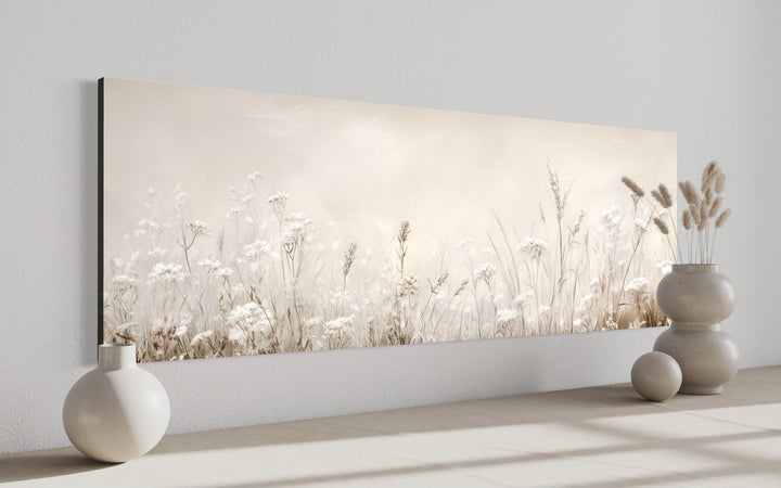 Horizontal canvas wall art of neutral wildflowers and meadow grasses in beige and off-white tones.