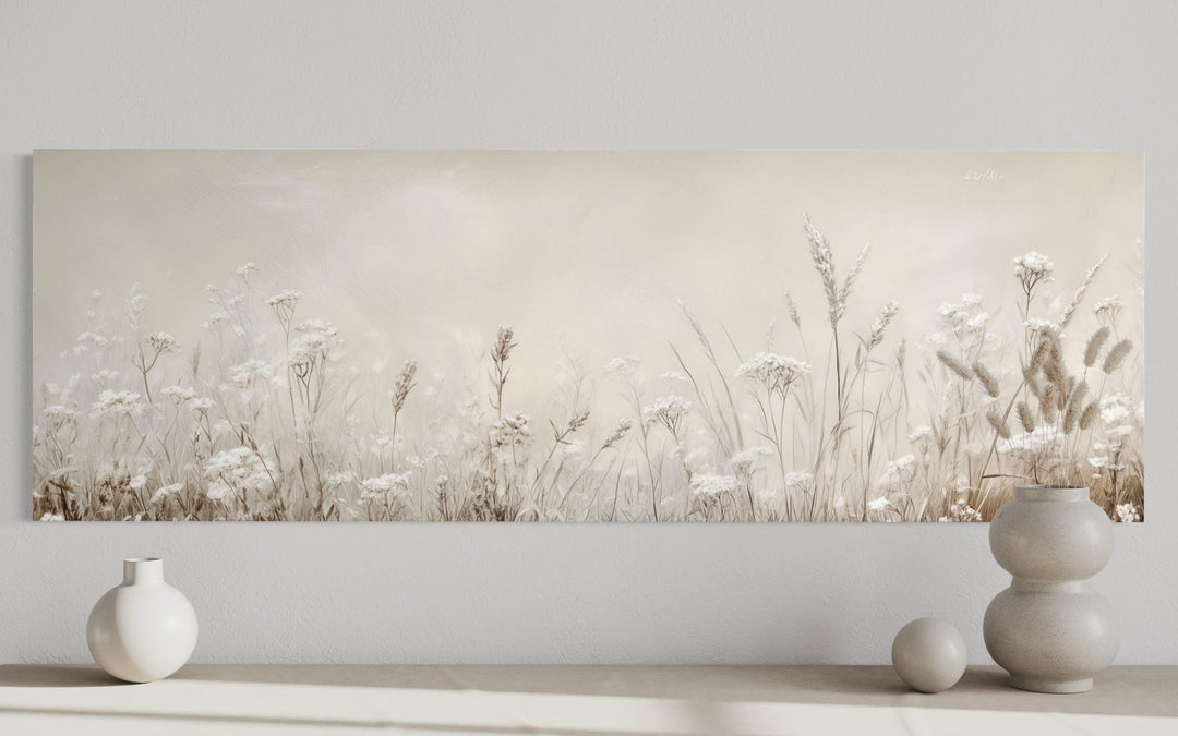 Horizontal canvas wall art featuring neutral beige wildflowers and grasses above a minimalist shelf.