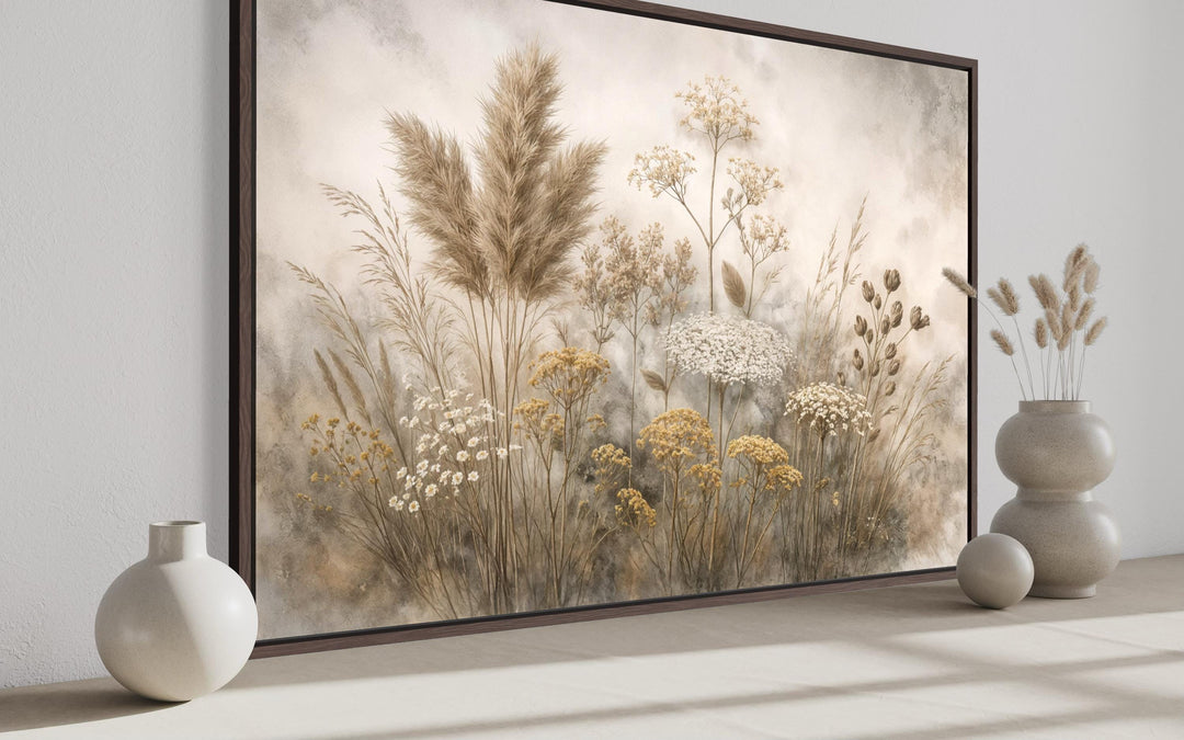 Neutral wildflowers botanical canvas print in a dark wood frame with beige and ivory tones.