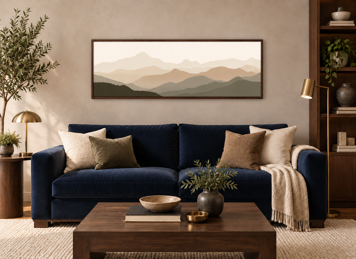 Neutral beige and brown minimalist mountain landscape wall art in a dark wood frame above a sofa.