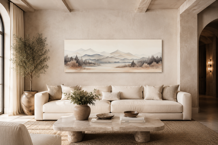 Neutral beige mountains lake long narrow framed canvas wall art hanging above a white sofa.