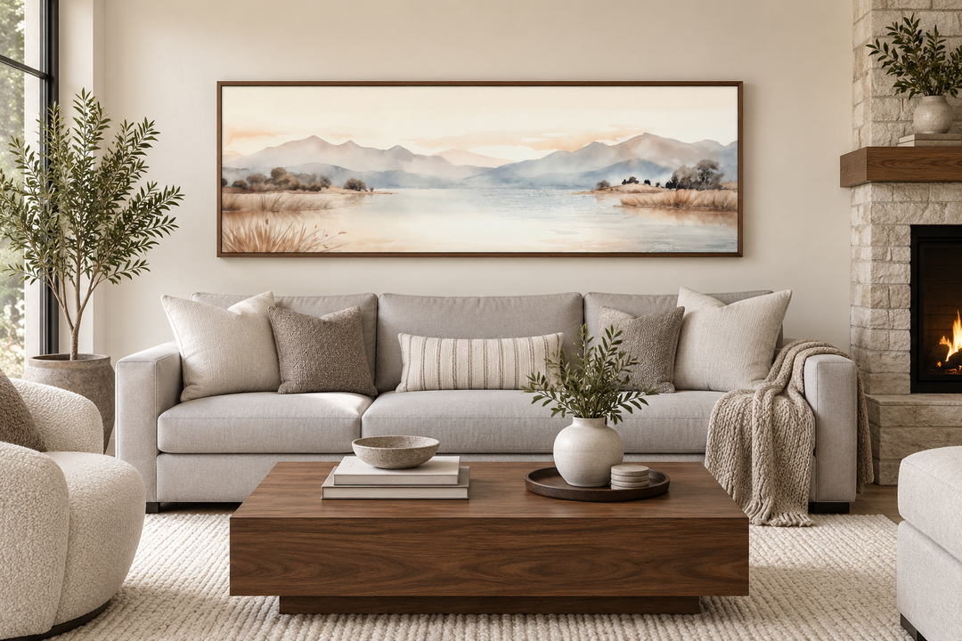 Boho neutral mountain landscape horizontal wall art in a brown frame above a light gray sofa.