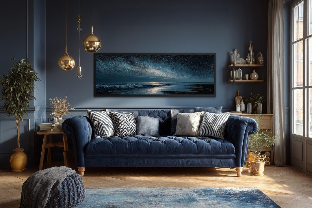 Panoramic dark blue seascape canvas print with a starry sky above a navy blue sofa.