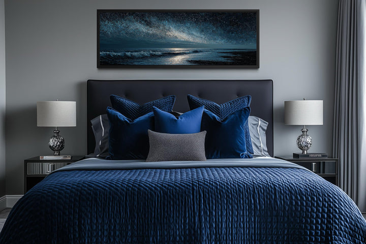 Panoramic dark blue seascape canvas print with a starry sky above a modern navy blue bed.