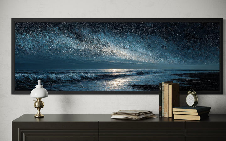 Panoramic dark blue seascape canvas print of a starry night ocean above a dark dresser.
