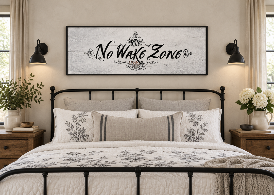 No Wake Zone long narrow framed canvas wall art hanging above a black iron bed in a bedroom.