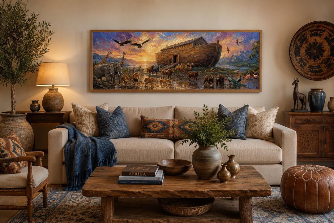 Long horizontal canvas of Noah's Ark with animals at sunset, hung above a sofa in a living room.