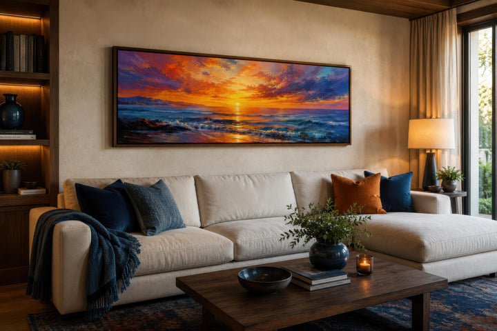 Panoramic ocean sunset canvas art with fiery orange and purple sky above a modern living room sofa.