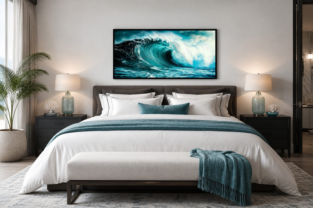 Ocean wave photography framed canvas wall art hanging above a bed in a modern coastal bedroom.