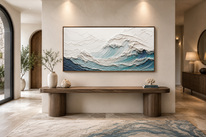 Textured 3D teal ocean wave canvas art above a wooden console table in a modern neutral room.