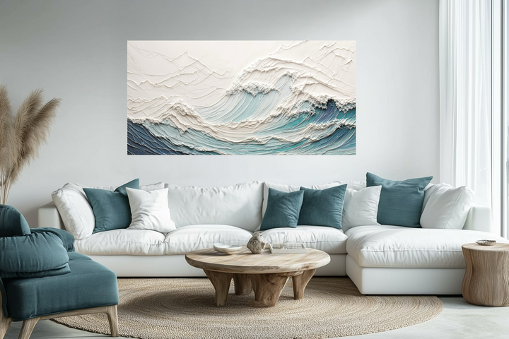 Textured teal and white ocean wave canvas art displayed above a modern white sectional sofa.
