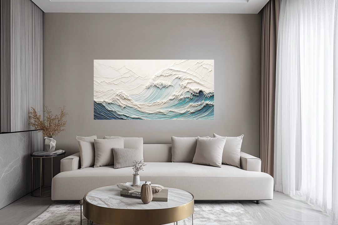 Textured teal and white ocean wave canvas art hanging above a modern beige sofa in a living room.
