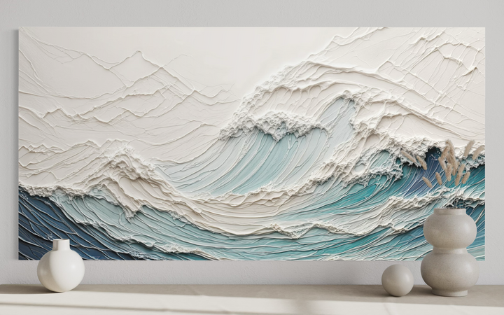 Textured 3D teal and white ocean wave canvas art displayed on a wall above minimalist vases.