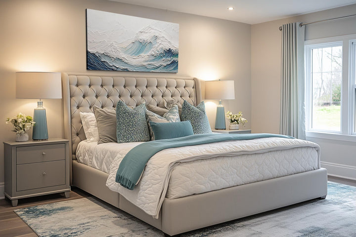 Ocean wave wall art with a 3D illusion teal wave canvas hangs above a tufted bed in a modern bedroom.