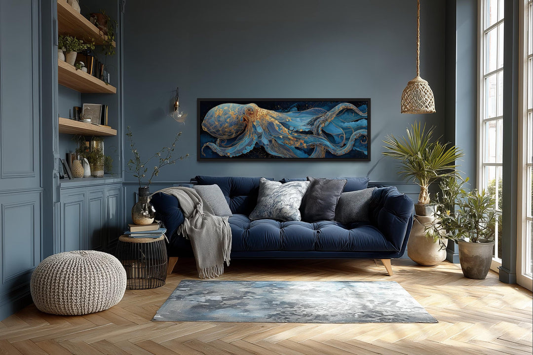 Horizontal canvas wall art of a blue and gold octopus in a coastal living room above a navy sofa.