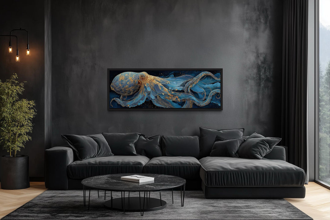 Horizontal octopus canvas wall art with blue and gold details above a black sofa in a dark room.