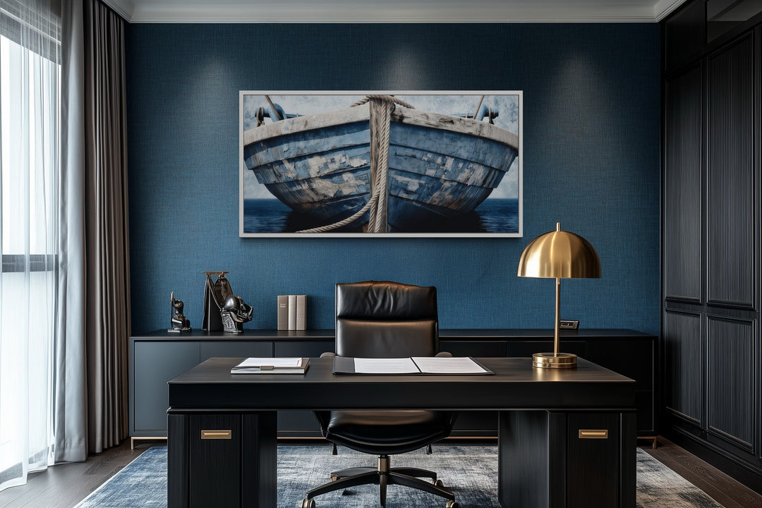 Old blue and white rustic boat nautical framed canvas wall art in a dark blue office setting.