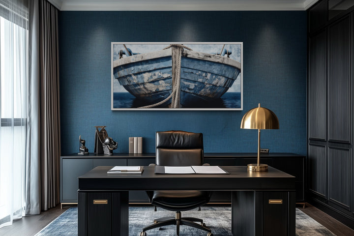 Old blue and white rustic boat nautical framed canvas wall art in a dark blue office setting.