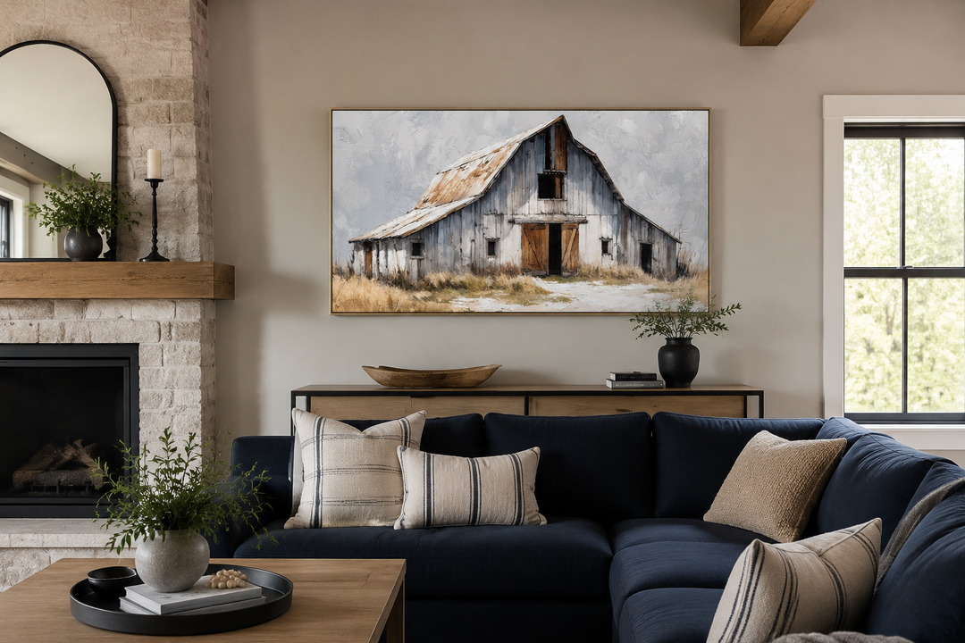 Rustic canvas wall art of an old grey barn with a rusted roof in a modern farmhouse living room.