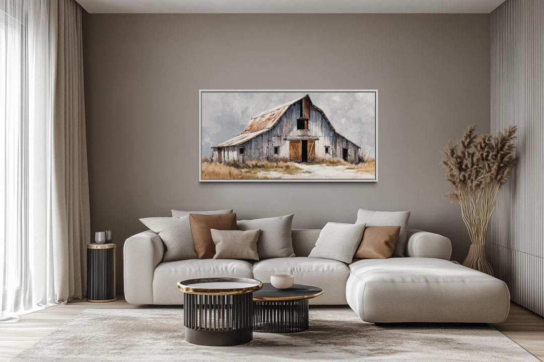 Old grey barn canvas wall art in a rustic farmhouse living room above a neutral sofa.