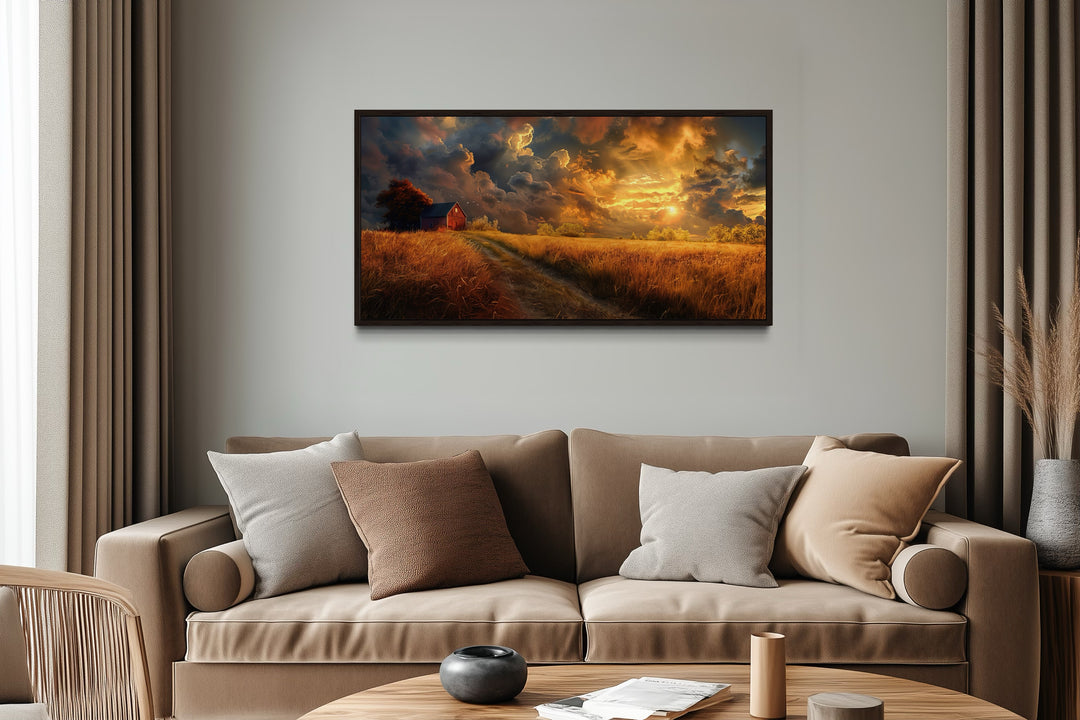 Old red barn in autumn sunset framed canvas wall art hanging above a modern beige sofa.